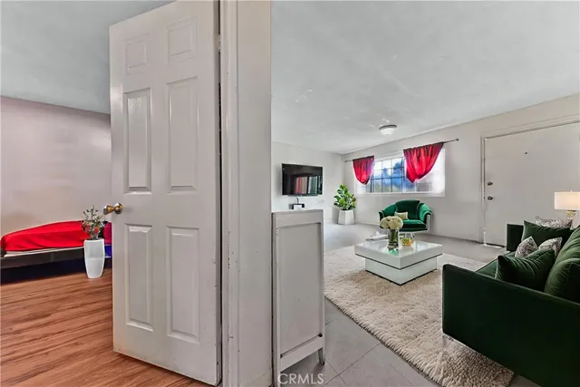 a bedroom with a large bed and a flat tv screen on dresser