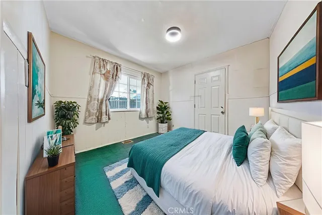 a bedroom with a bed and a potted plant