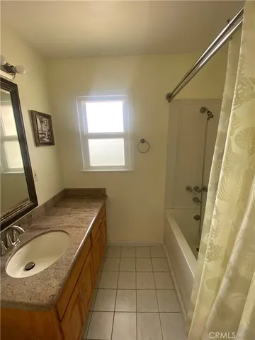 a bathroom with a granite countertop sink a mirror and a bathtub