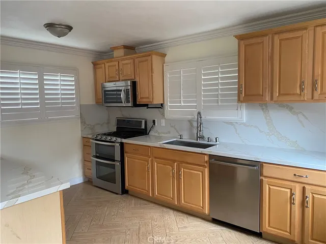 a kitchen with stainless steel appliances granite countertop a stove a sink and a microwave