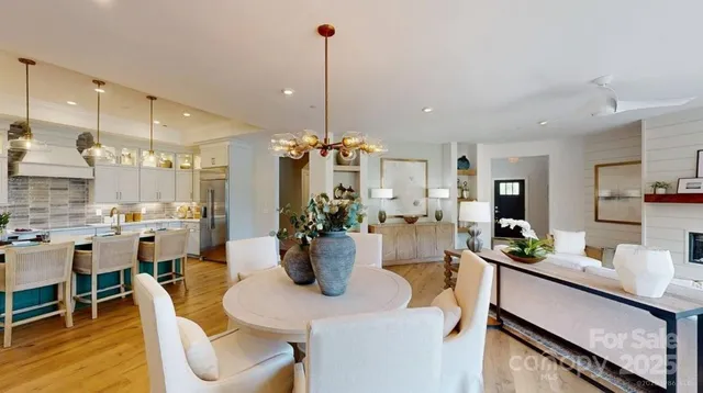 a view of a dining room and livingroom with furniture wooden floor a chandelier
