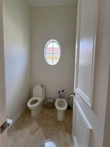 a bathroom with a toilet and a mirror
