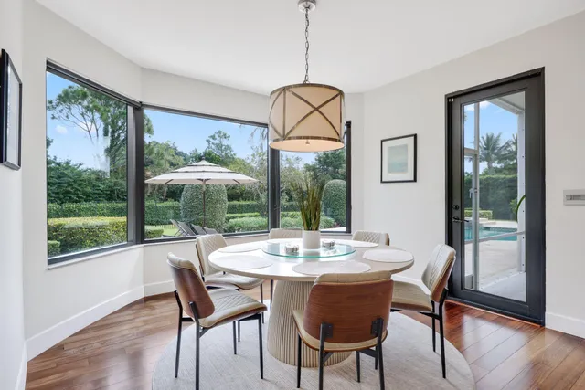 a dining room with furniture window and wooden floor