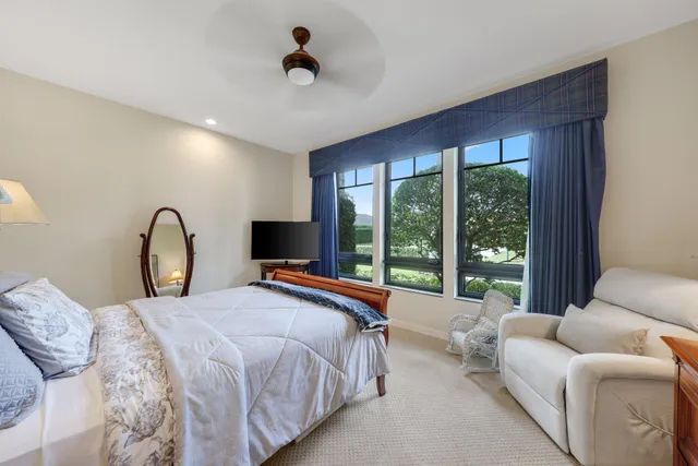 a bedroom with a bed and a large window