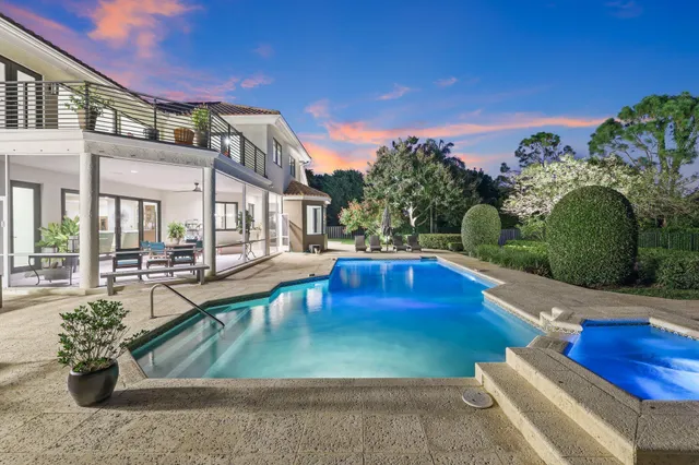 a view of a house with swimming pool and sitting area
