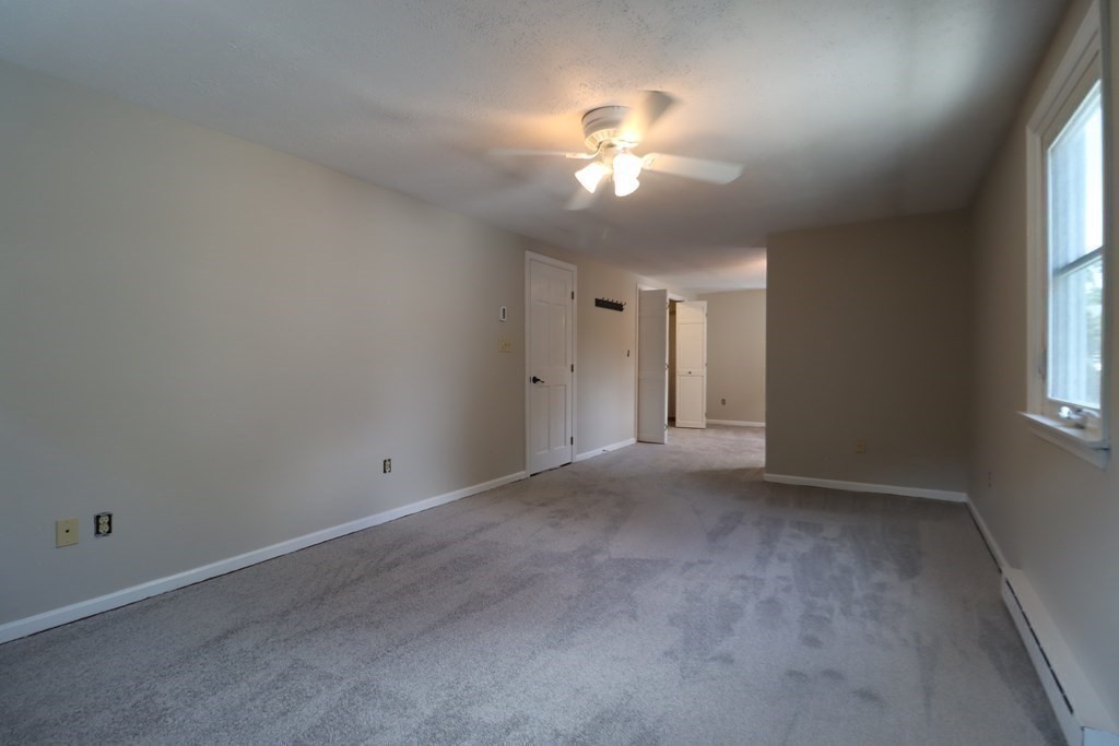 31 Longview Way Peabody, MA 01960 - Photo 21 of 42 an empty room with chandelier fan and windows