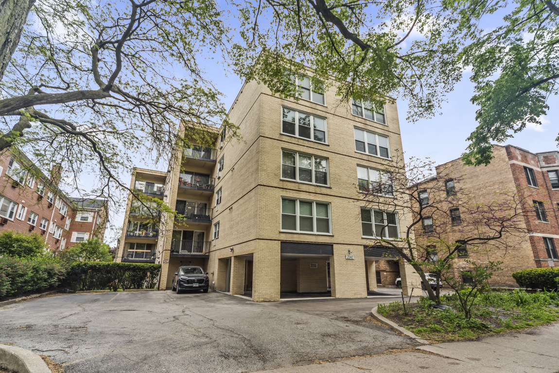 a front view of a multi story building with a yard