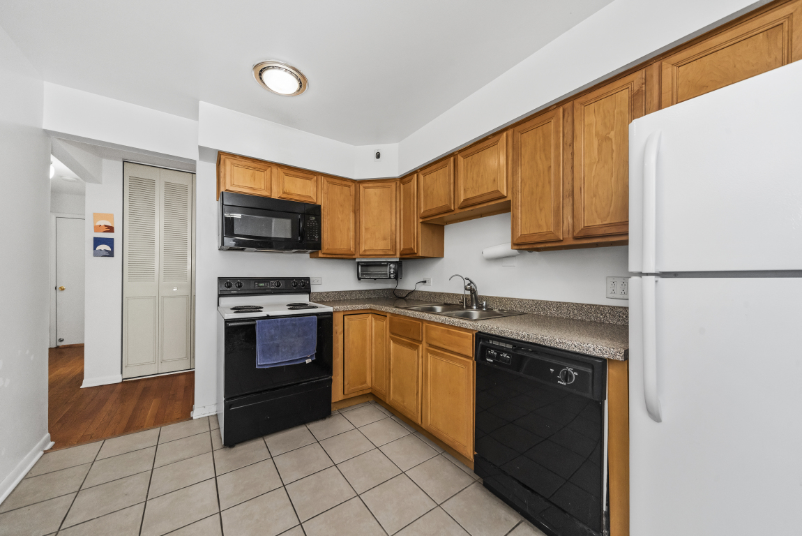2141 Ridge Avenue, Unit 2B Evanston, IL 60201 - Photo 8 of 17 a kitchen with stainless steel appliances granite countertop a refrigerator sink and stove