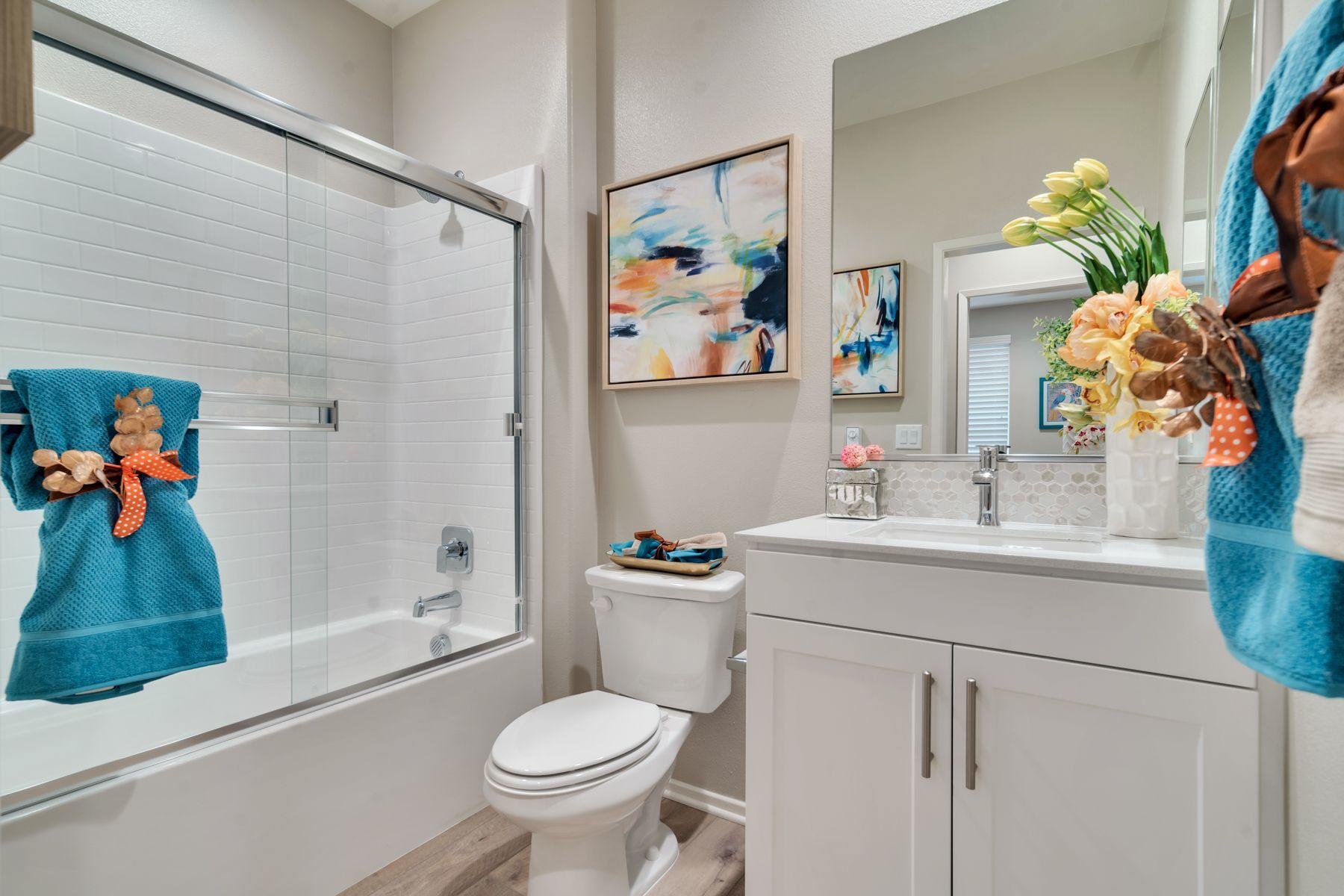 1748 East Holguin Street Lancaster, CA 93535 - Photo 15 of 20 a bathroom with a sink a toilet and shower curtain