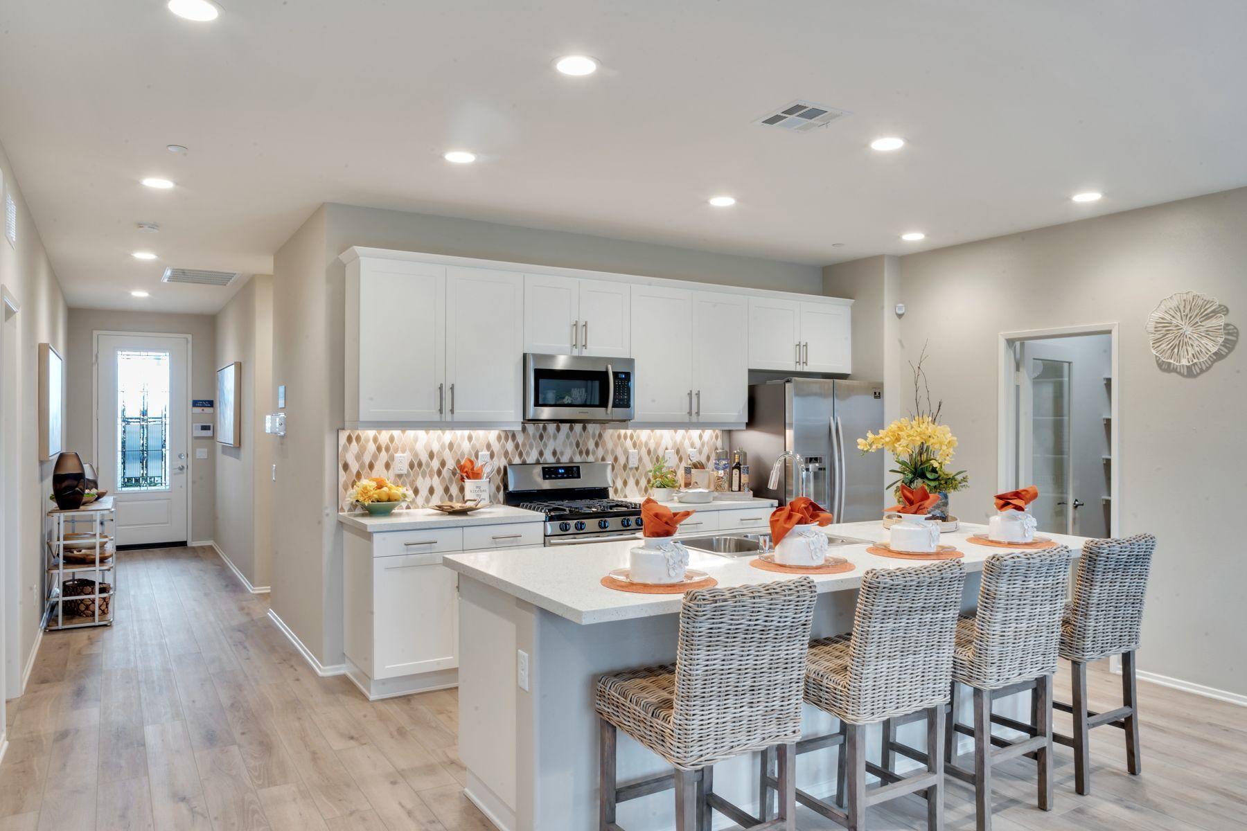 1748 East Holguin Street Lancaster, CA 93535 - Photo 3 of 20 a kitchen with stainless steel appliances kitchen island granite countertop a dining table chairs refrigerator and microwave