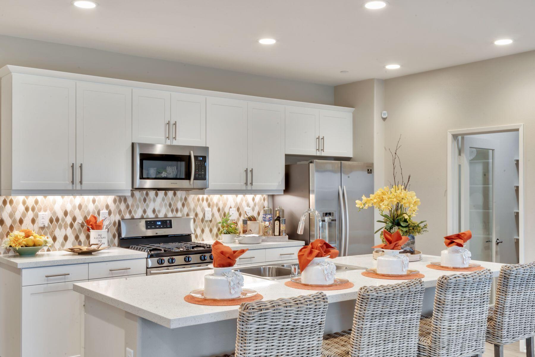 1748 East Holguin Street Lancaster, CA 93535 - Photo 4 of 20 a kitchen with stainless steel appliances kitchen island granite countertop a sink dishwasher stove and white cabinets