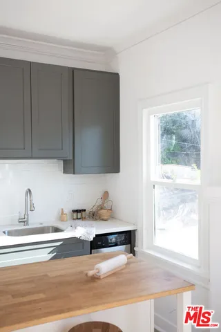 a kitchen with a sink a window and cabinets
