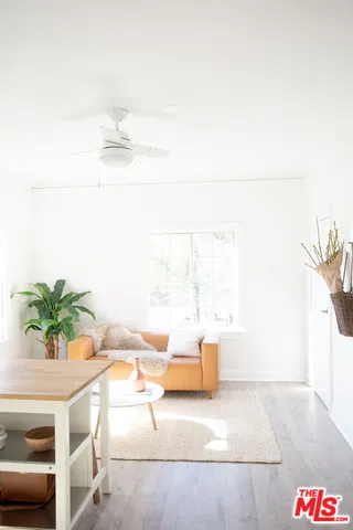 a living room with a white wall and a wall painting