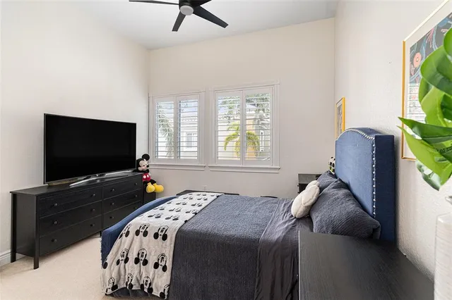 a bedroom with a bed and a flat tv screen on dresser