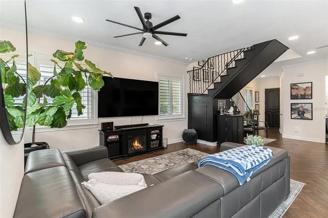 a living room with furniture a flat screen tv and a potted plant