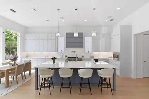 a large white kitchen with a stove and a sink