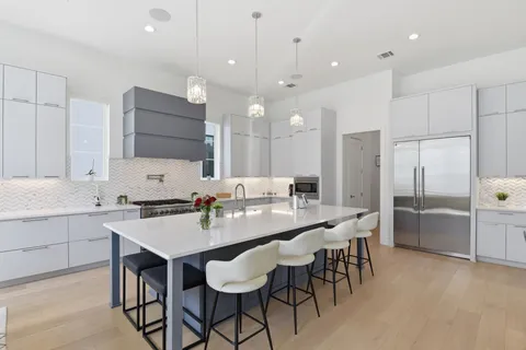a large kitchen with a counter space a sink appliances and a large window