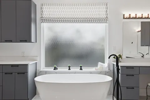 a bedroom with a bed a desk and chair with the wooden floor