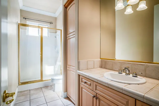 a bathroom with a granite countertop sink a toilet and a mirror