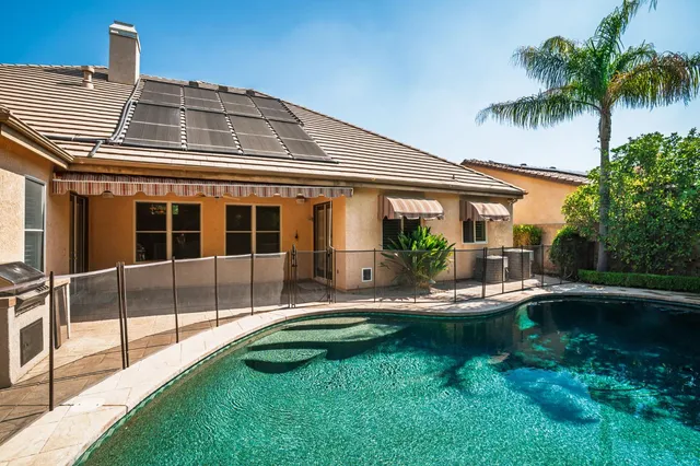 a front view of a house with swimming pool having outdoor seating