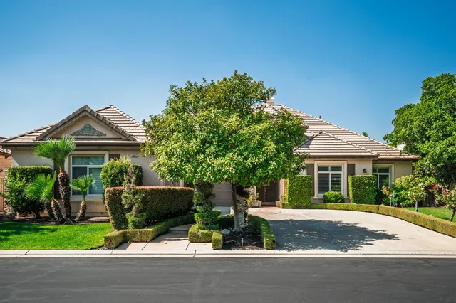 a front view of a house with a garden and plants