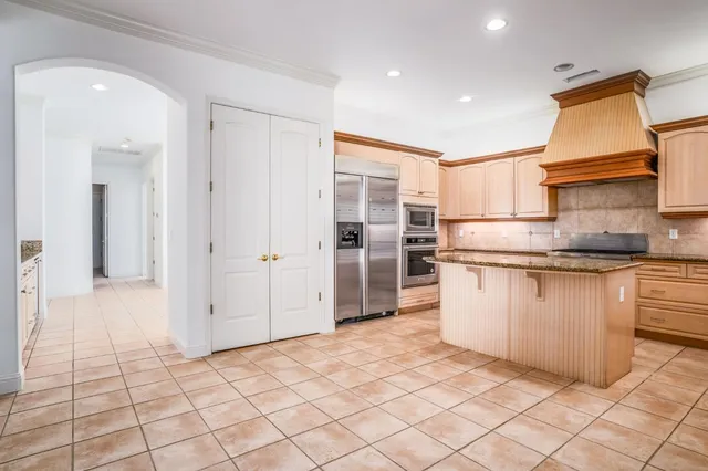 a view of a kitchen with kitchen island granite countertop a refrigerator and a sink
