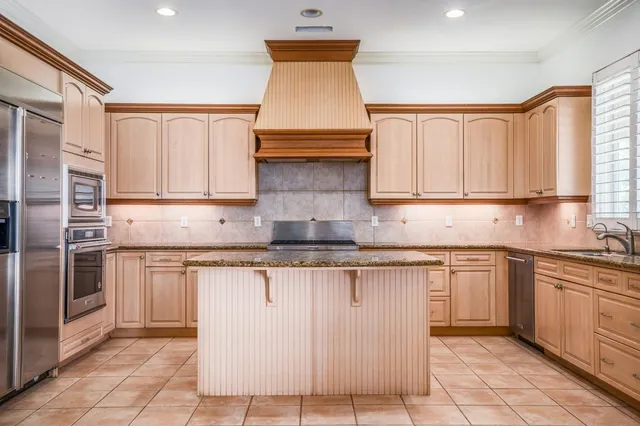 a kitchen with stainless steel appliances granite countertop a stove a sink and a microwave