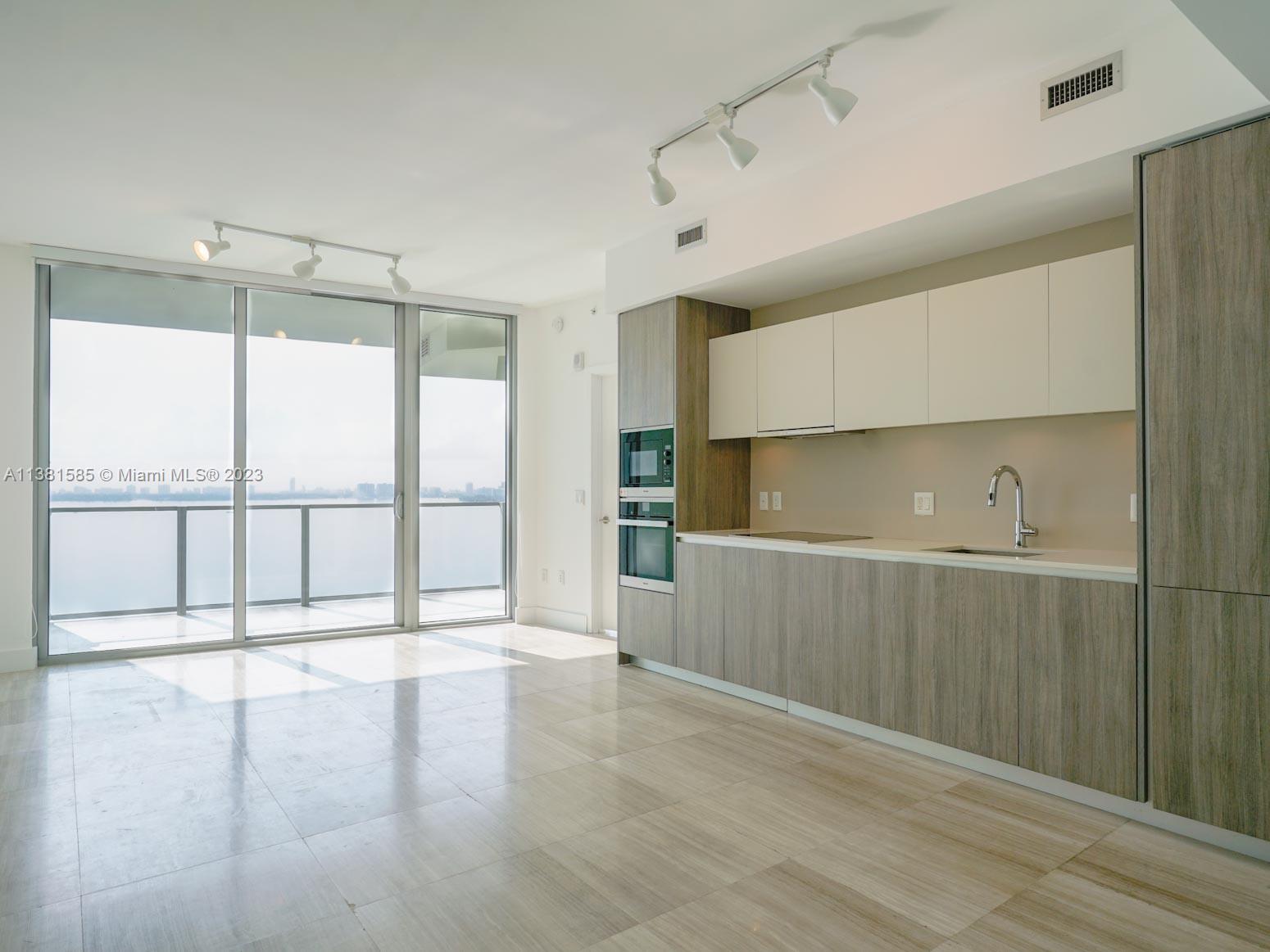 Edgewater Miami, FL 33137 - Photo 19 of 42 a view of an empty room with wooden floor and a window