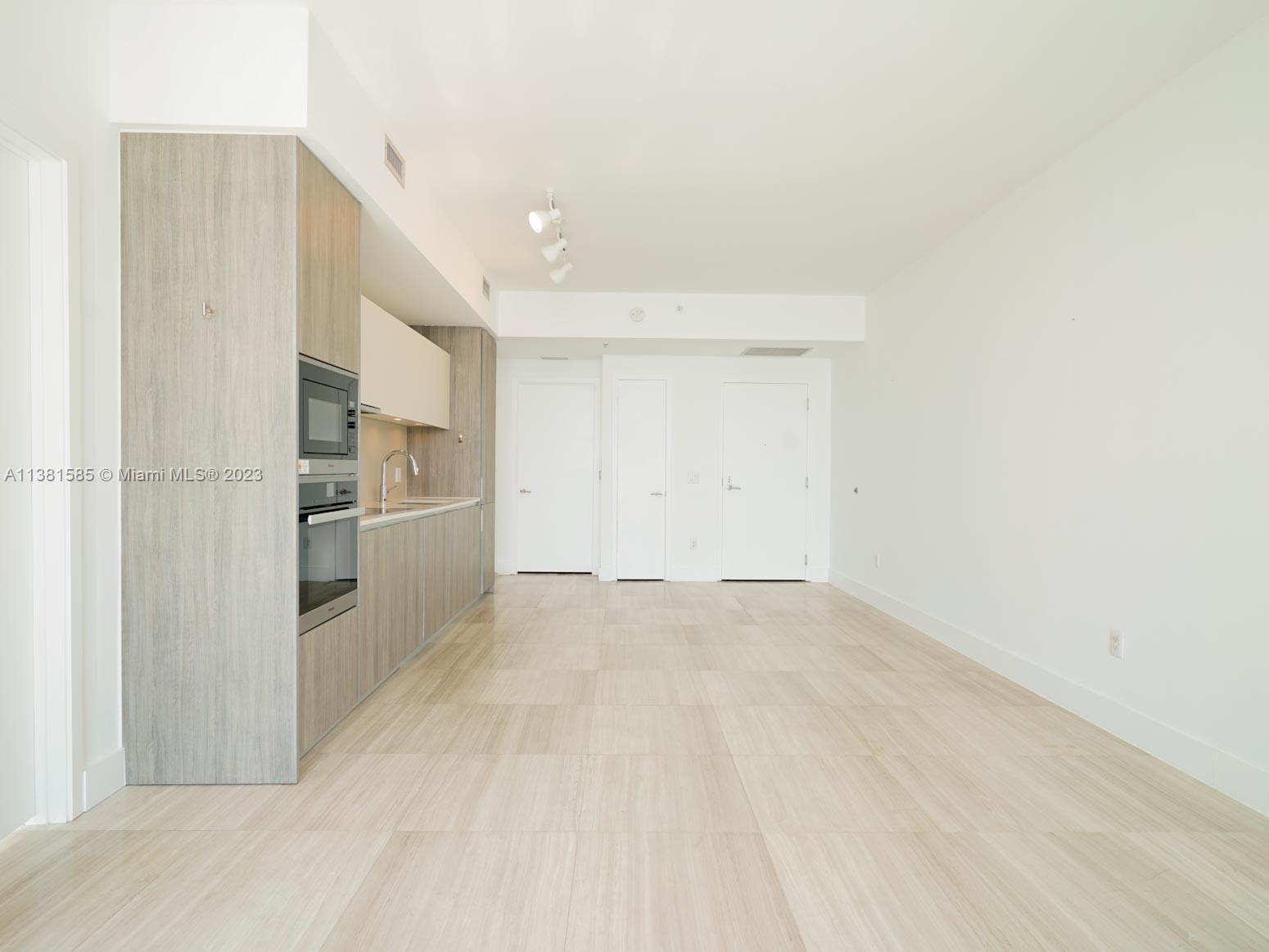 Edgewater Miami, FL 33137 - Photo 21 of 42 a view of a kitchen with white cabinets and refrigerator