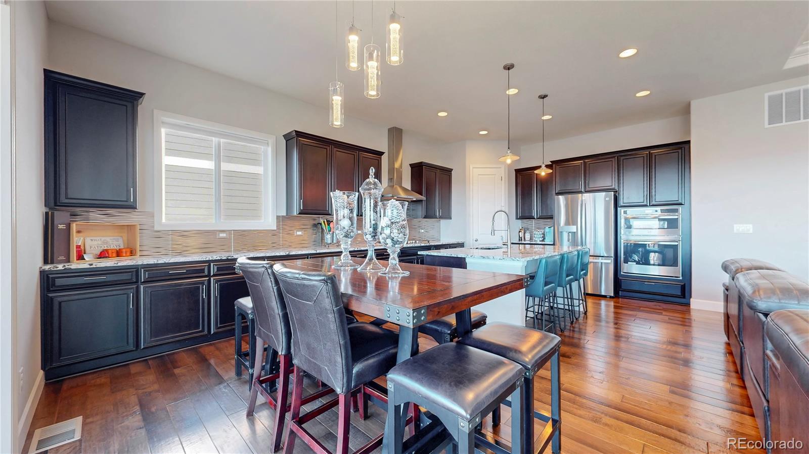 20249 Terrace View Drive Parker, CO 80134 - Photo 9 of 38 a dining room with stainless steel appliances kitchen island granite countertop a table chairs and a refrigerator