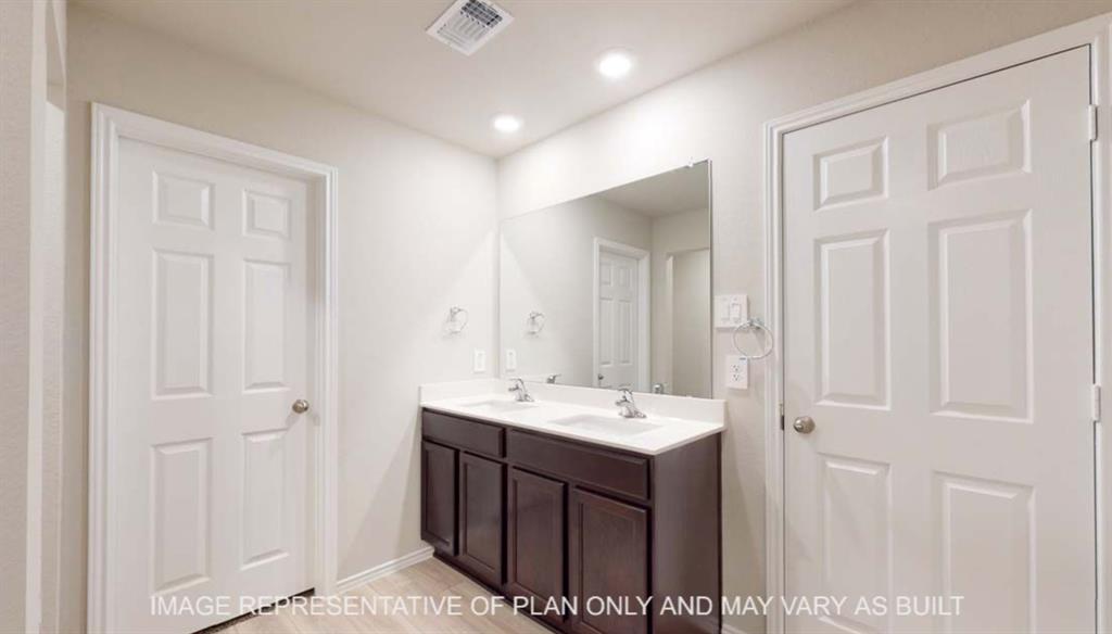 10429 Neptune Court Waco, TX 76708 - Photo 11 of 16 Double vanity with integrated sinks, wood-finish cabinetry, a large wall-mounted mirror, and recessed lighting