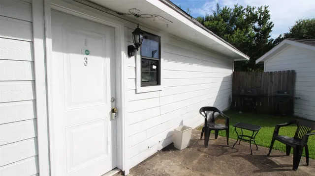a view of a door and chair front of house