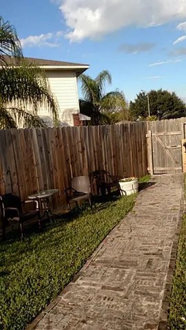 a view of a backyard with wooden fence