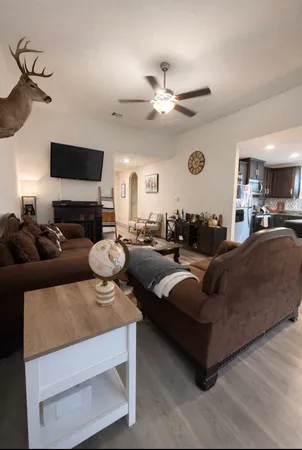 a living room with furniture a ceiling fan and a fireplace