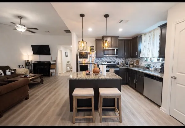 a large kitchen with cabinets table and chairs