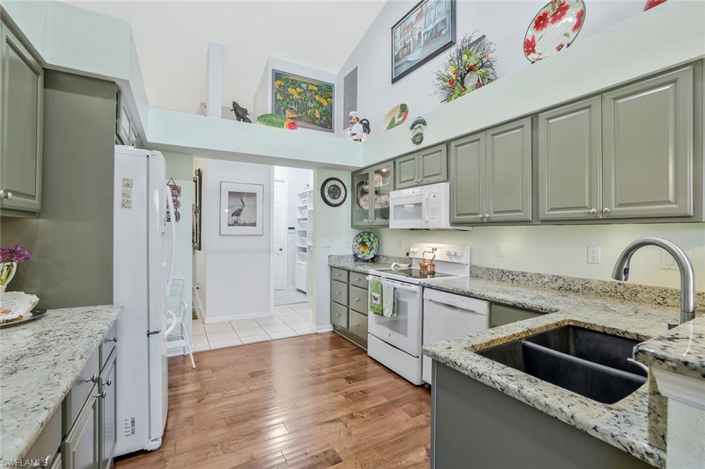 186 Muirfield Circle Naples, FL 34113 - Photo 11 of 32 a kitchen with stainless steel appliances granite countertop a sink and cabinets