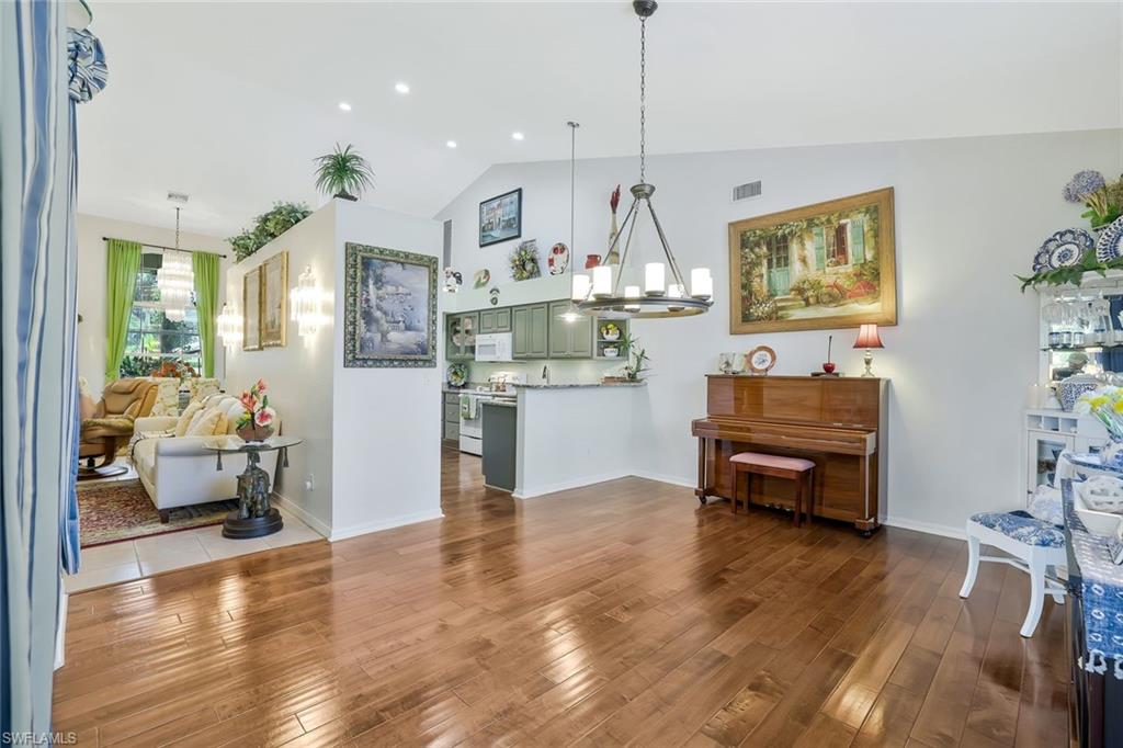 186 Muirfield Circle Naples, FL 34113 - Photo 14 of 32 a living room with kitchen island furniture and a wooden floor