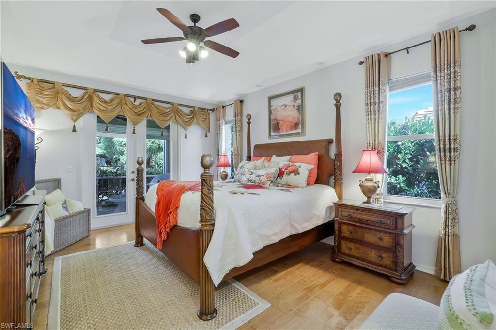 186 Muirfield Circle Naples, FL 34113 - Photo 16 of 32 a bedroom with a bed and a chandelier fan