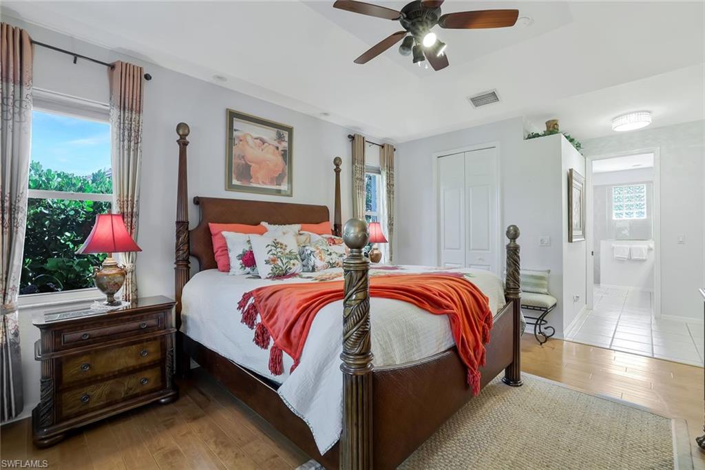 186 Muirfield Circle Naples, FL 34113 - Photo 17 of 32 a bedroom with bed and a chandelier