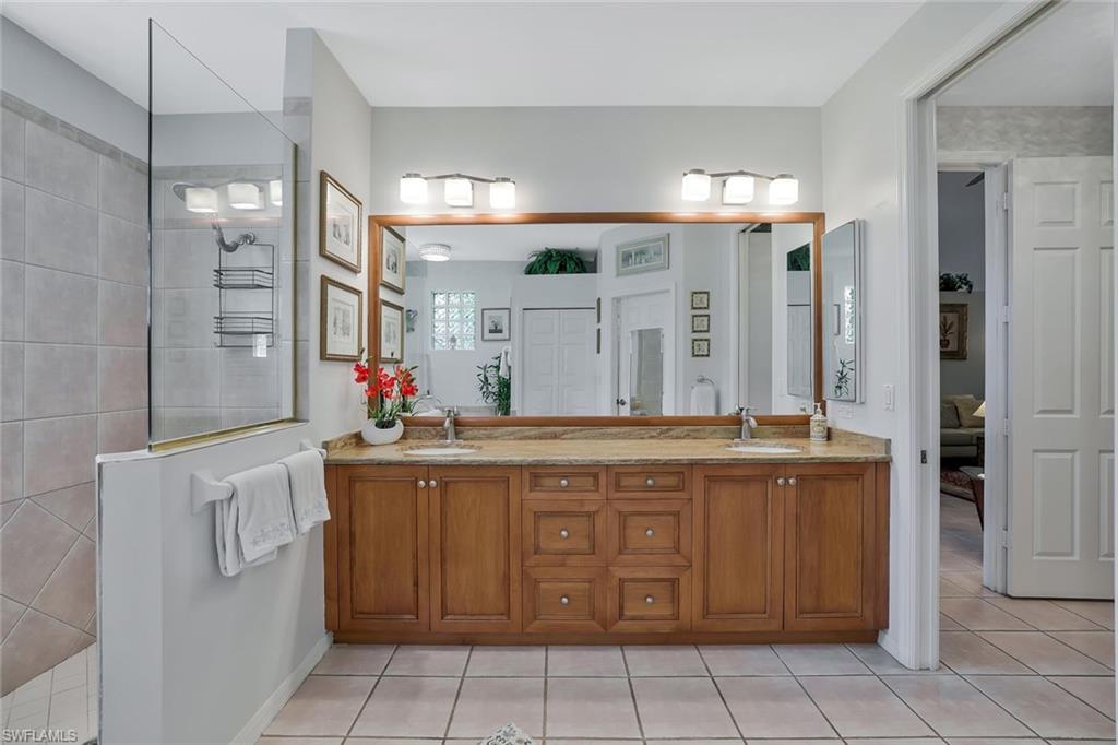 186 Muirfield Circle Naples, FL 34113 - Photo 19 of 32 a spacious bathroom with a granite countertop sink and a mirror