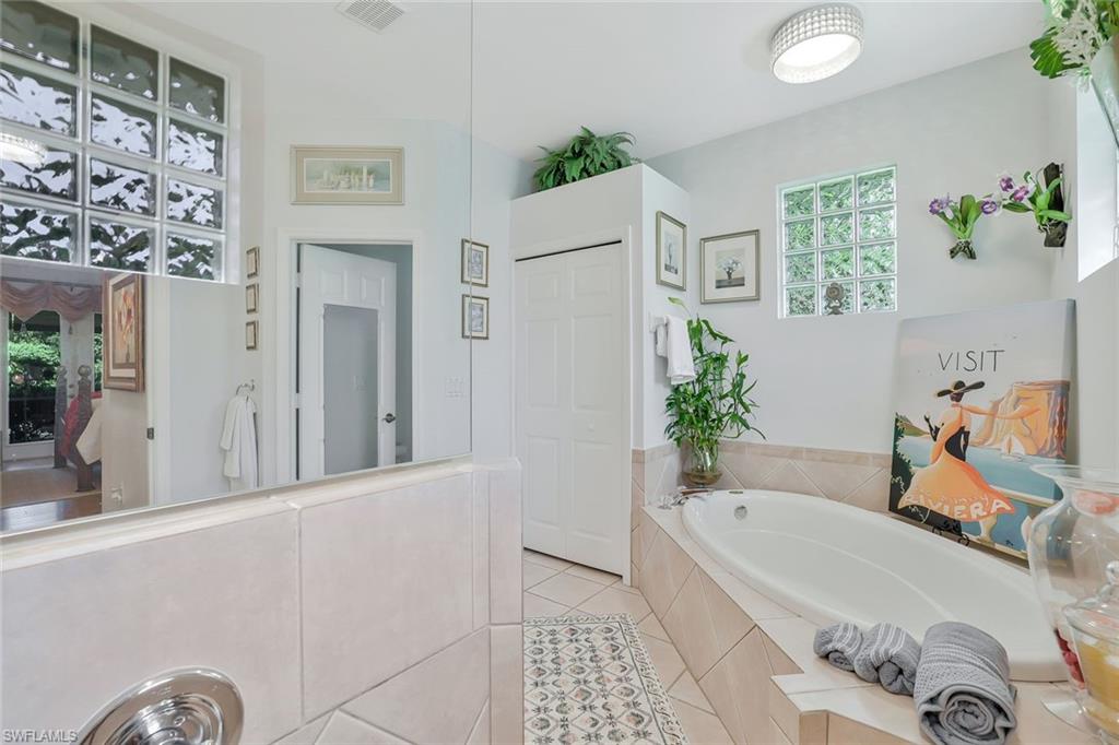 186 Muirfield Circle Naples, FL 34113 - Photo 20 of 32 a bathroom with a tub sink and mirror