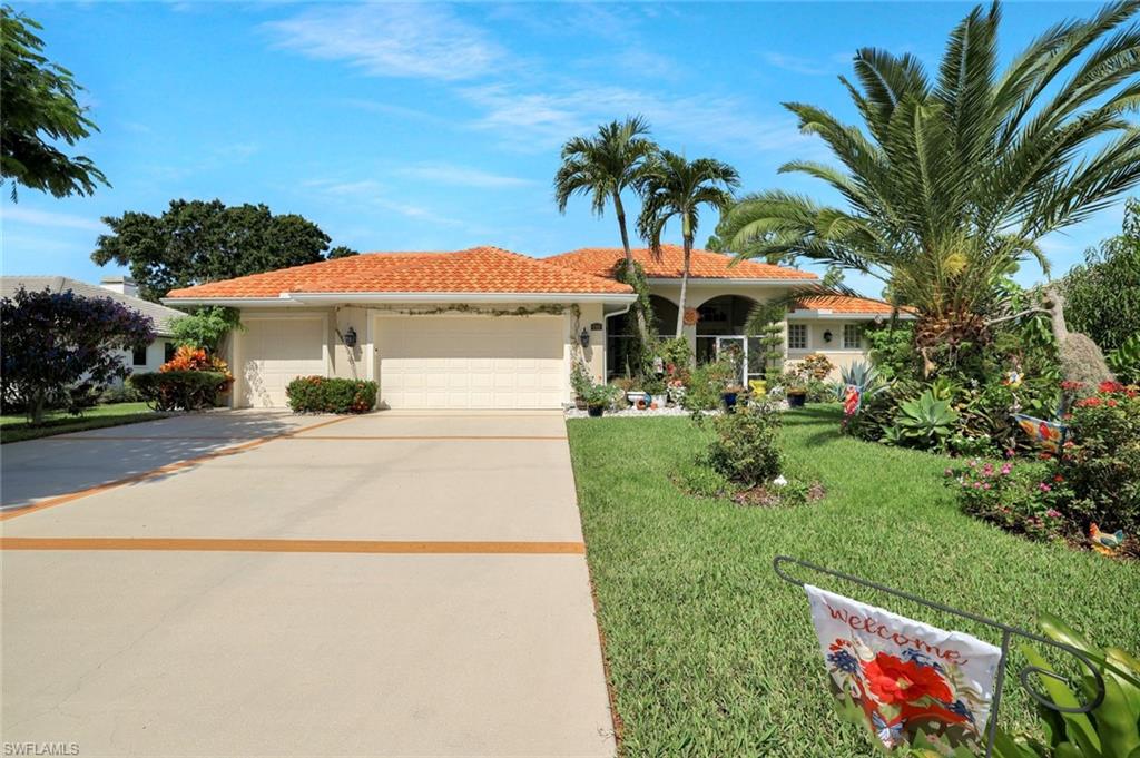 186 Muirfield Circle Naples, FL 34113 - Photo 2 of 32 a front view of a house with a yard and palm tree