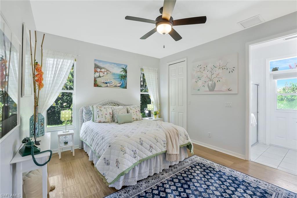 186 Muirfield Circle Naples, FL 34113 - Photo 21 of 32 a bedroom with a bed and a painting on the wall
