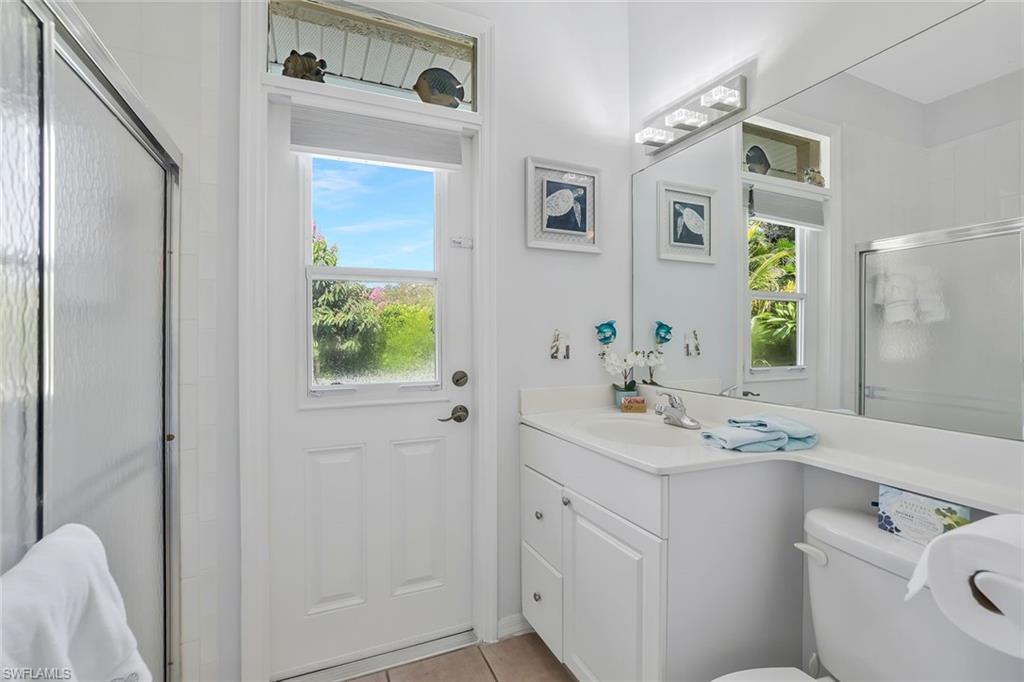 186 Muirfield Circle Naples, FL 34113 - Photo 22 of 32 a bathroom with a sink a toilet and a mirror
