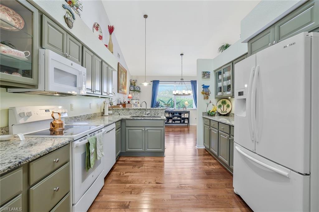186 Muirfield Circle Naples, FL 34113 - Photo 9 of 32 a kitchen with stainless steel appliances granite countertop a refrigerator a sink dishwasher and a stove with wooden floor