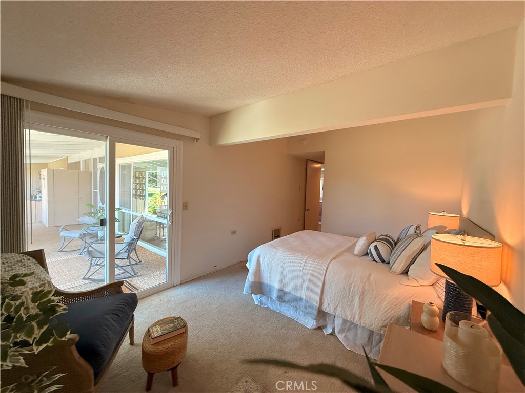 13560 Medinac Lane, Unit 102B Seal Beach, CA 90740 - Photo 16 of 24 a bedroom with a bed and wooden floor