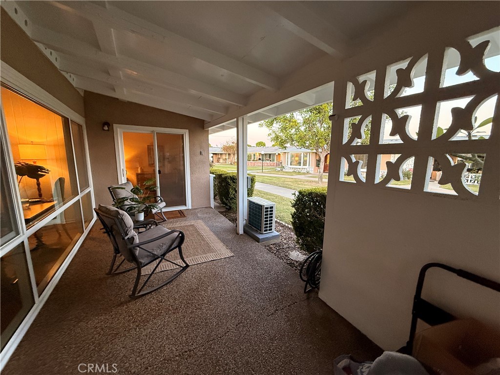 13560 Medinac Lane, Unit 102B Seal Beach, CA 90740 - Photo 21 of 24 a living room with furniture and a floor to ceiling window
