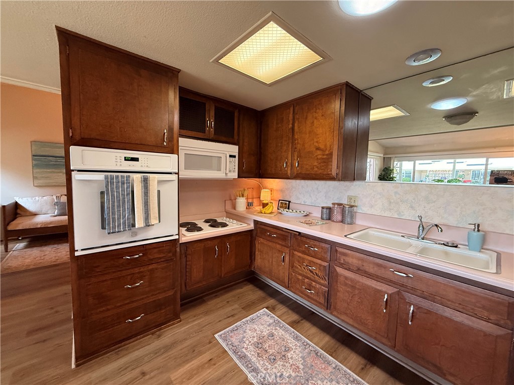 13560 Medinac Lane, Unit 102B Seal Beach, CA 90740 - Photo 5 of 24 a kitchen with stainless steel appliances granite countertop a sink stove and cabinets