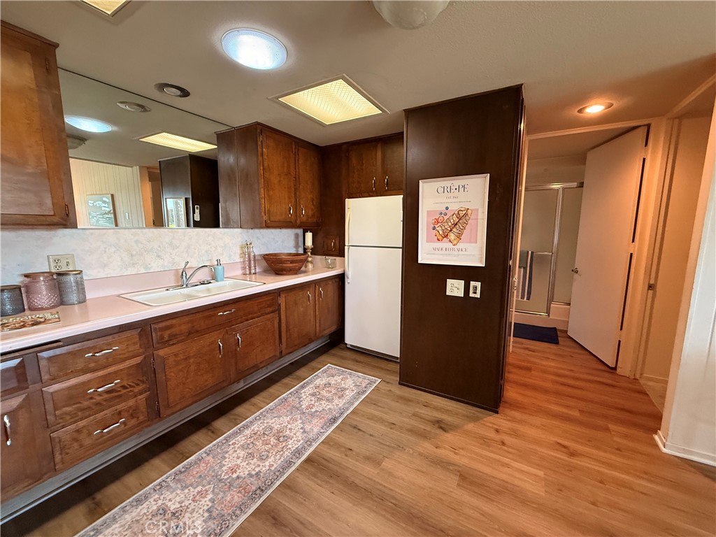 13560 Medinac Lane, Unit 102B Seal Beach, CA 90740 - Photo 7 of 24 a kitchen with stainless steel appliances granite countertop a refrigerator and a sink