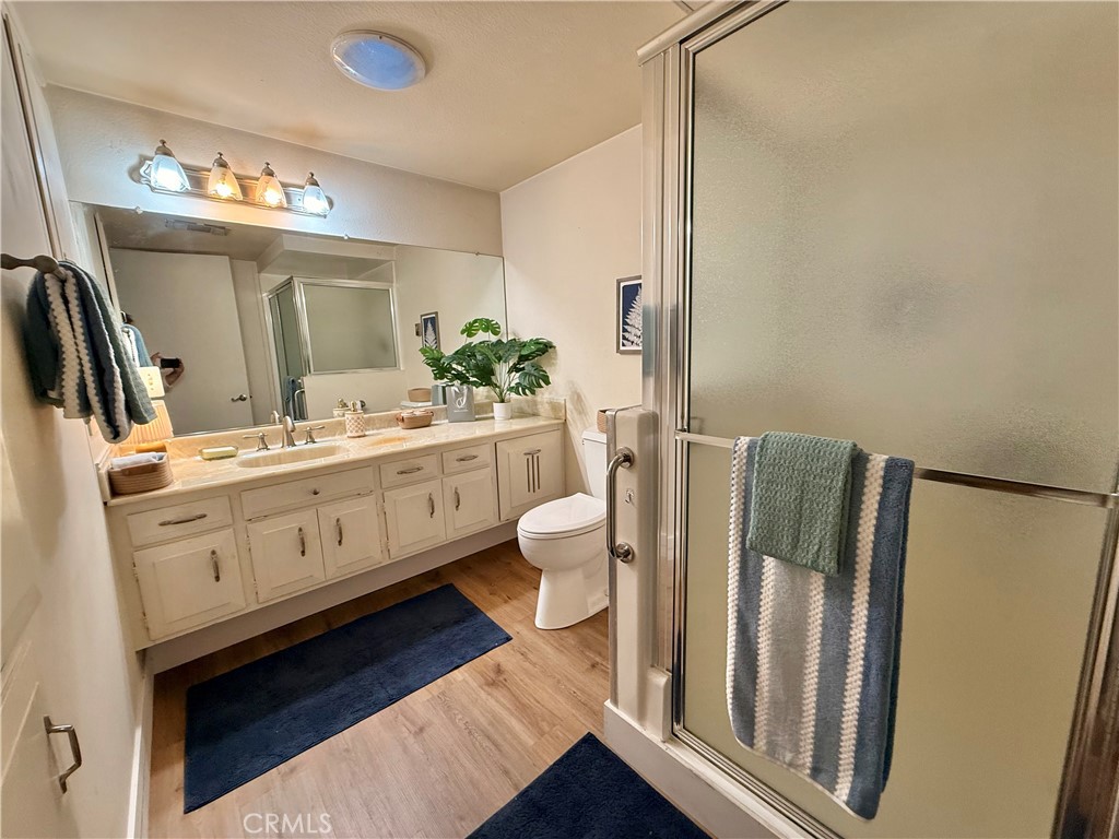 13560 Medinac Lane, Unit 102B Seal Beach, CA 90740 - Photo 10 of 24 a bathroom with a double vanity sink mirror and toilet